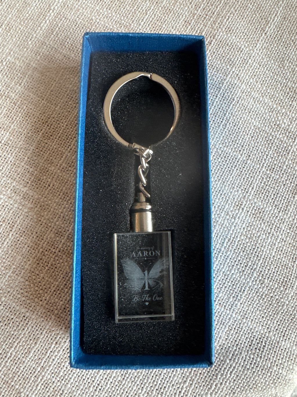 Unlit rectangular Be The One memorial keychain in its blue presentation box
